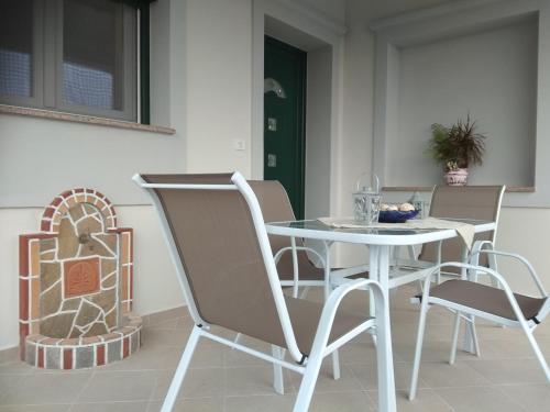Una mesa y sillas blancas en una habitación. en Myrina View, en Mirina