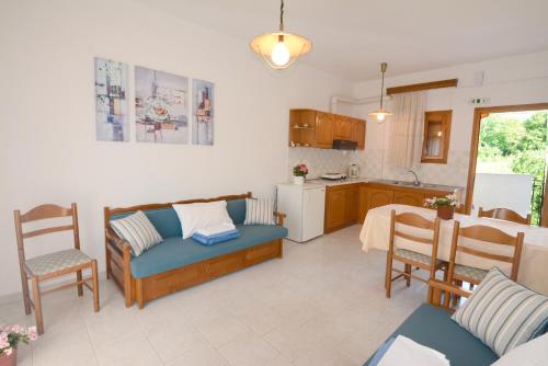 a living room and kitchen with a couch and a table at Okeanis Apartments in Kala Nera