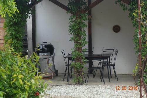 a patio with a table and chairs and a grill at Pensiunea Deceneu in Slănic