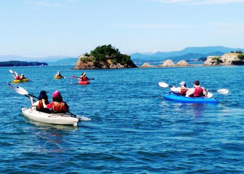 a group of people kayaking on a body of water at Tabinoyado Ushionoakari Geiboso in Shima