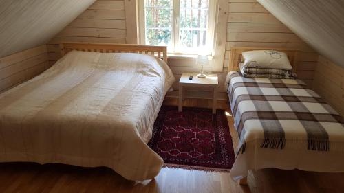 a bedroom with two beds and a window at Vienkiemis prie Merkinės in Merkinė