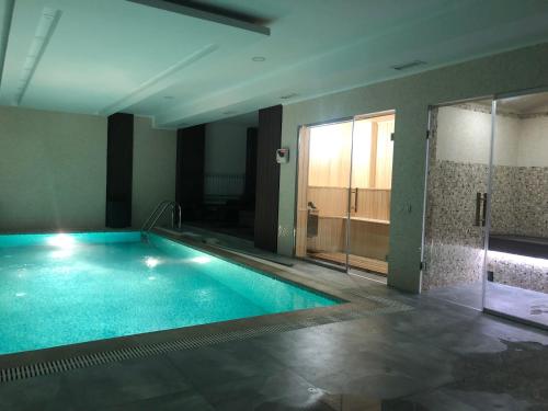 una grande piscina in una stanza con doccia di Astor Hotel & Spa a Bishkek