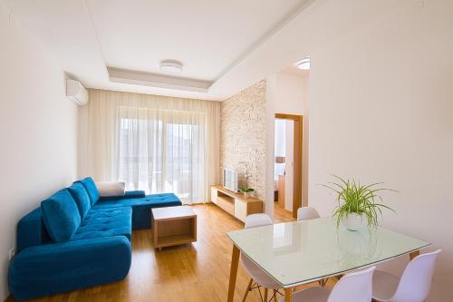 a living room with a blue couch and a table at Eukaliptus in Becici