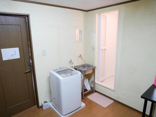 a small refrigerator in a room with a window at Guest House Twenty-Seven 27 in Osaka