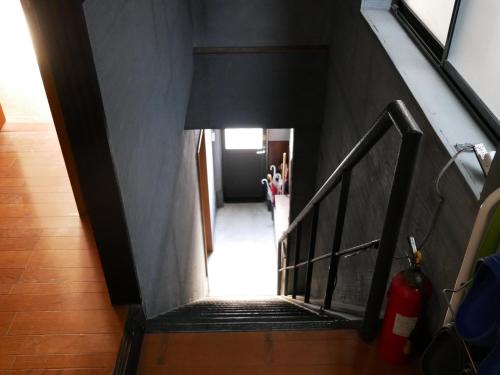 a stairway leading to a hallway with a black wall at Guest House Twenty-Seven 27 in Osaka