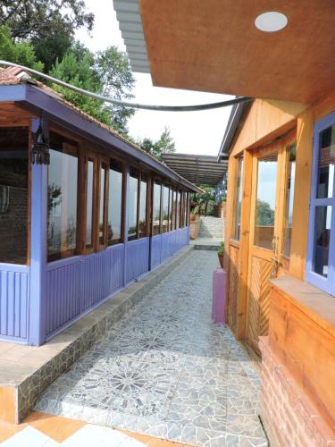 a walkway leading to a building with windows at Joy Source Resort in Kathmandu