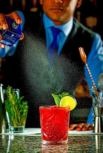 a man in a suit is spraying a drink at George Limerick Hotel in Limerick