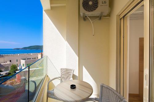 a balcony with a table and chairs and a view of the ocean at Eukaliptus in Becici