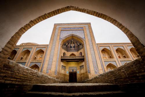 a view of a building through an archway at Orient Star Khiva Hotel- Madrasah Muhammad Aminkhan 1855 in Khiva