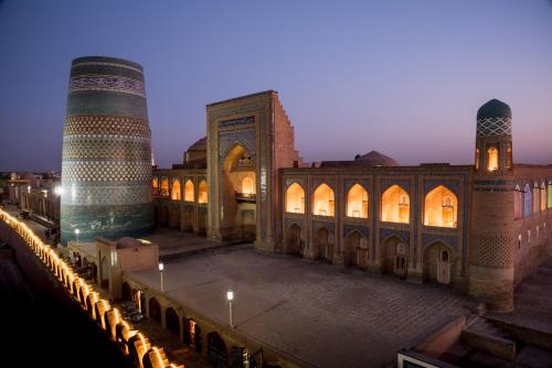 uma vista para um edifício com uma mesquita e um minarete em Orient Star Khiva Hotel- Madrasah Muhammad Aminkhan 1855 em Khiva