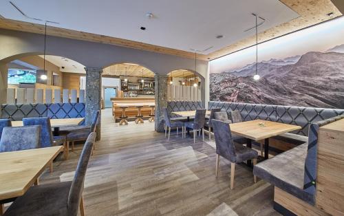 a restaurant with tables and chairs and a piano at Rosentalerhof Hotel & Appartements in Saalbach Hinterglemm