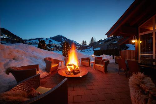 a fire pit on a patio in the snow at night at Rosentalerhof Hotel & Appartements in Saalbach Hinterglemm