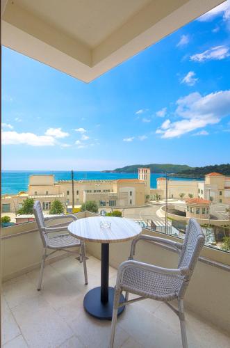 a table and chairs on a balcony with a view of the ocean at Eukaliptus in Becici