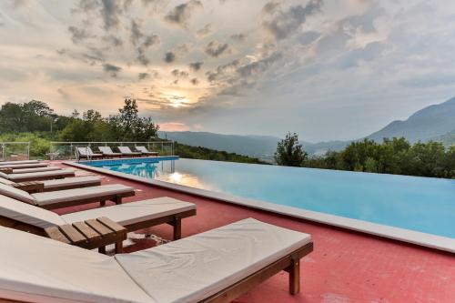 a pool with chaise lounge chairs and a resort at Resort Bevilacqua in Budva