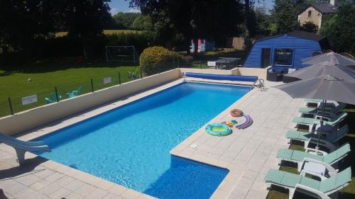 une vue aérienne d'une piscine avec des chaises et un parasol dans l'établissement La Metairie & Cottages, à Camors