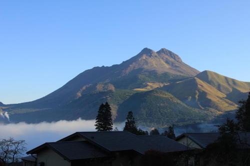 a mountain in the distance with a house in the foreground at Yufuin-Sanso Waremokou in Yufuin