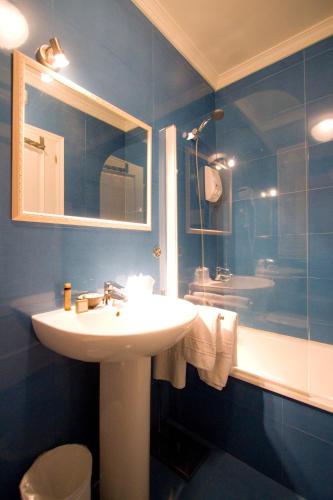 a blue bathroom with a sink and a shower at Hotel Mi Norte in Ribadeo