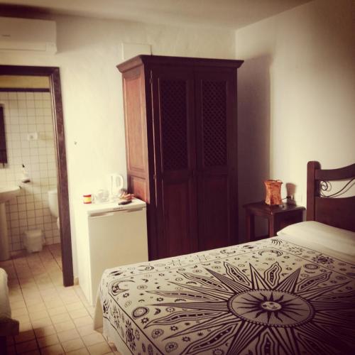 a bedroom with a bed and a cabinet and a bathroom at Casa Lareymora in Algarrobo