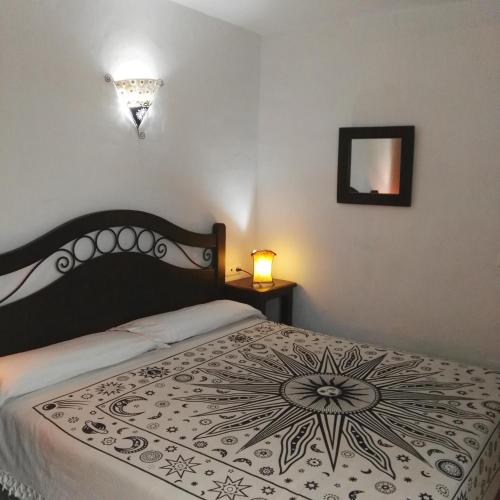 a bedroom with a bed with a black and white blanket at Casa Lareymora in Algarrobo