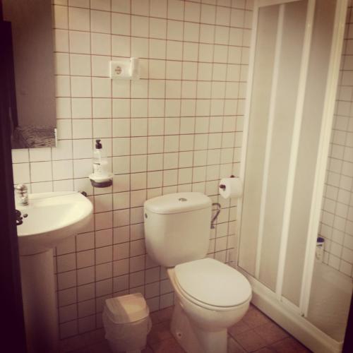 a white bathroom with a toilet and a sink at Casa Lareymora in Algarrobo