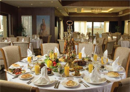 a dining room with a table with food on it at Thousand Nights Hotel Amman - فندق ثاوزند نايتس عمان in Amman