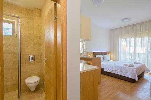 a bathroom with a bed and a toilet and a sink at Eukaliptus in Becici