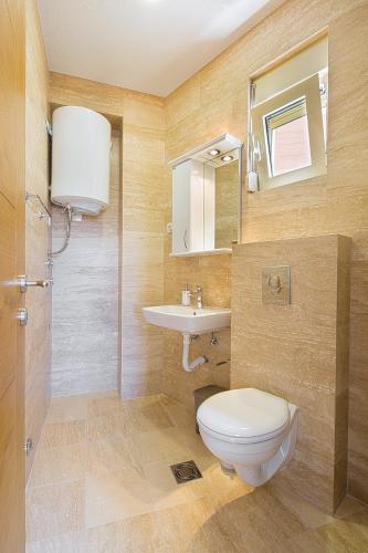 a bathroom with a toilet and a sink at Eukaliptus in Becici