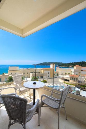 a balcony with chairs and a table and a view of the ocean at Eukaliptus in Becici