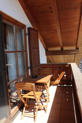 a wooden table and chairs on a balcony at Ferienwohnung Pferdehof Pankratz in Iffeldorf