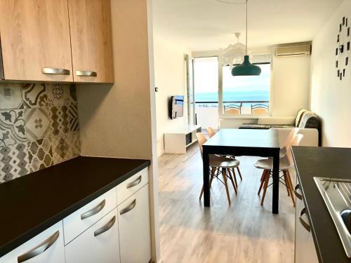 a kitchen and living room with a table and a dining room at Seaview Apartment in Koper