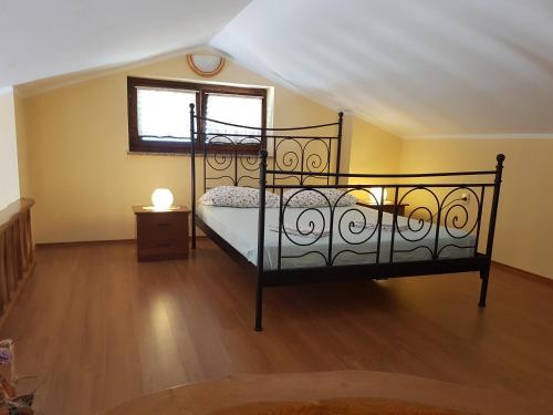 a bedroom with a black bed with a window at Apartments Villa Maran in Umag