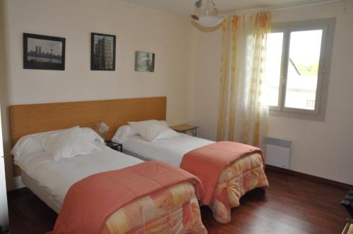 Salles-CuranにあるLe Mas Capelのベッド2台と窓が備わるホテルルームです。