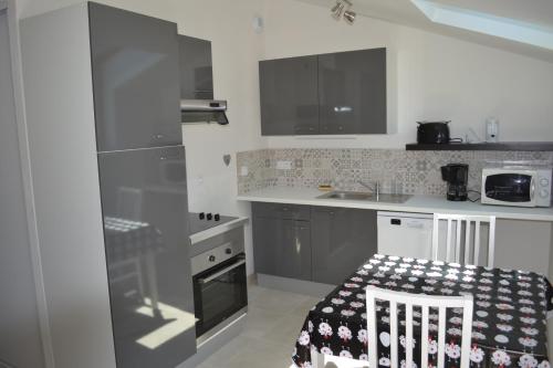 a small kitchen with a sink and a stove at Gîtes de la Bibudière in Le Boupère