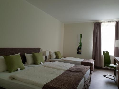 ein Hotelzimmer mit 2 Betten und einem Fenster in der Unterkunft Hotel Hof Münsterland in Ahlen