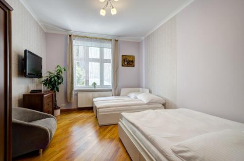 ソポトにあるDR Apartments - Seagullのベッドルーム(ベッド1台、ソファ、テレビ付)