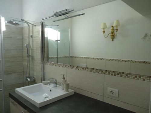 a bathroom with a sink and a shower and a mirror at Residenze Paradiso in Costa Paradiso