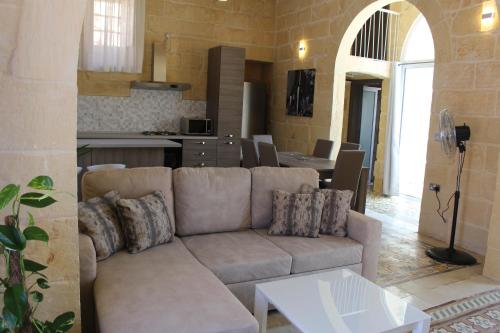 a living room with a couch and a kitchen at Simar in Qala