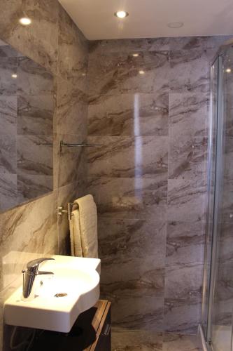 La salle de bains est pourvue d'un lavabo et d'une douche. dans l'établissement Simar, à Qala