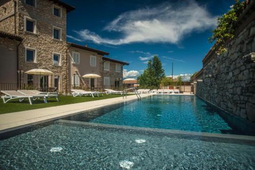 a swimming pool in front of a building at Relais Madergnago Gardapartments in Desenzano del Garda