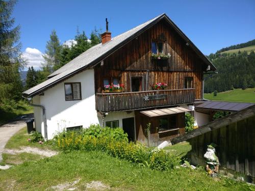 a house with a balcony with flowers on it at Zauneralm in Aich