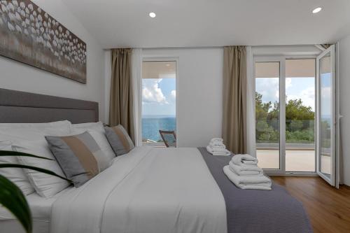 a bedroom with a large bed with a view of the ocean at Villa Zagradina in Baška Voda