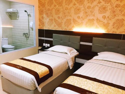 Tempat tidur dalam kamar di De Best Hotel