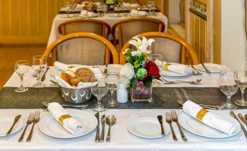 a table with white plates and utensils on it at Golden Tulip Nizwa Hotel in Nizwa