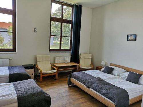 1 Schlafzimmer mit 2 Betten, einem Tisch und Stühlen in der Unterkunft Penzion Zamecek in Uherčice