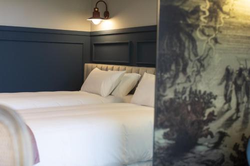 a bedroom with a bed with a painting on the wall at Hotel Mi Norte in Ribadeo