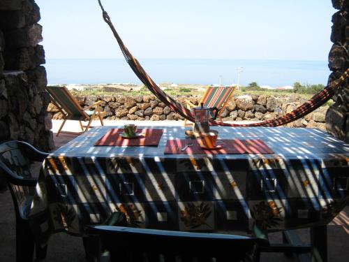 ein Tisch auf einem Balkon mit Blick auf das Meer in der Unterkunft Agriturismo Zibibbodoro in Pantelleria