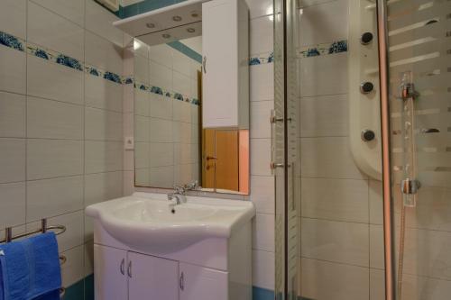 ein Badezimmer mit Waschbecken und Dusche in der Unterkunft Giselle in Mali Lošinj