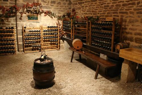 a wine cellar with a barrel and a bench and wine racks at Domaine et chambres d'Hôtes des Fées in Pretin