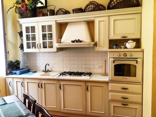 スカレアにあるScalea Historic Center Apartmentsのキッチン(白いキャビネット、シンク、コンロ付)