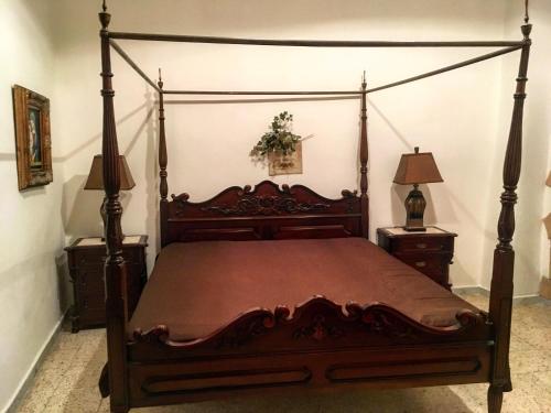 a bedroom with a wooden canopy bed with two night stands at Scalea Historic Center Apartments in Scalea